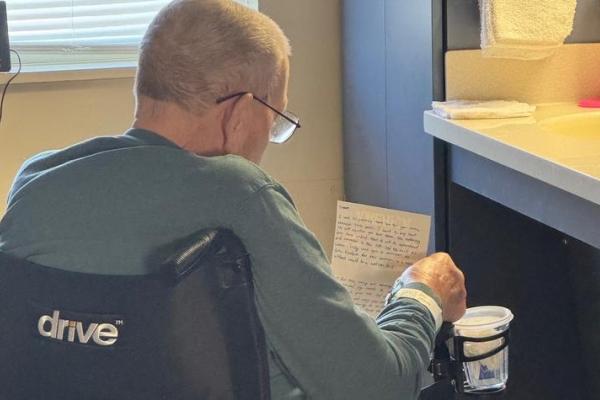A resident at Thomson-Hood Veterans Center reads a card sent by Singletary Scholars. The scholars made cards and goody bags for the veterans at the center. 