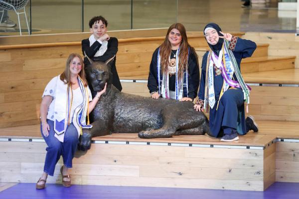 From left: Siena Pilati, Mostafa Mubarak, Carolina Burn and Fatimah Alomar pose with the Bowman Wildcat statue in the Gatton Student Center.