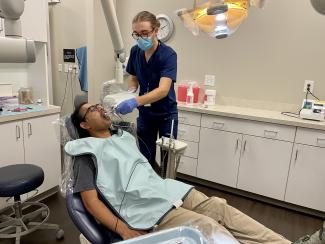 Student dentist checking the mouth of a patient.