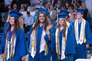 Maddie Duff waving with other graduating students walking