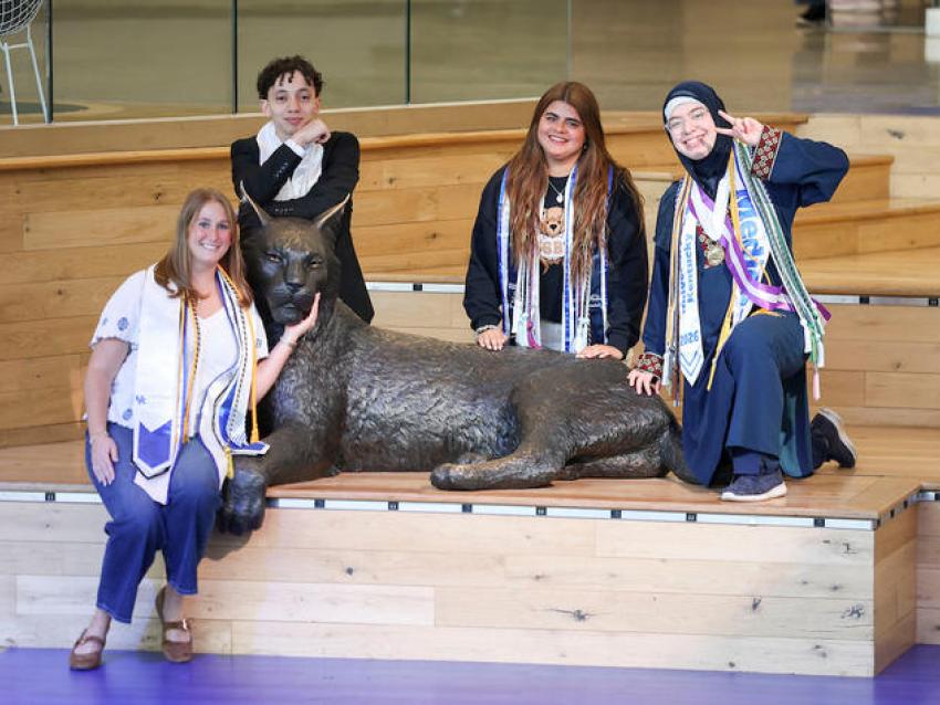 From left: Siena Pilati, Mostafa Mubarak, Carolina Burn and Fatimah Alomar pose with the Bowman Wildcat statue in the Gatton Student Center.